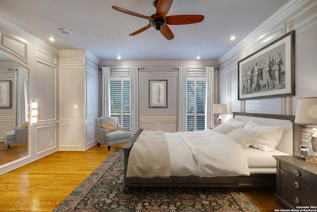 bedroom featuring ceiling fan, ornamental molding, and light wood-type flooring