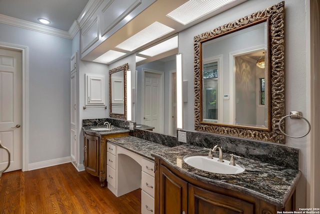 bathroom featuring hardwood / wood-style flooring, ornamental molding, and vanity