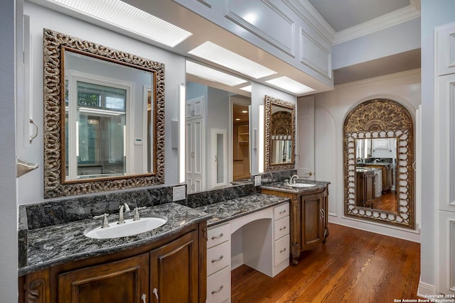 bathroom featuring hardwood / wood-style flooring, ornamental molding, and vanity