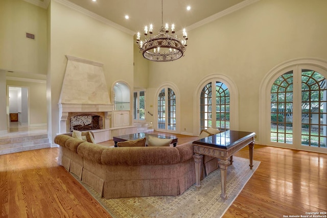 living room featuring a fireplace, light wood-type flooring, and a towering ceiling