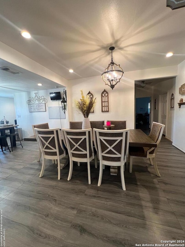 dining area with dark hardwood / wood-style flooring and an inviting chandelier