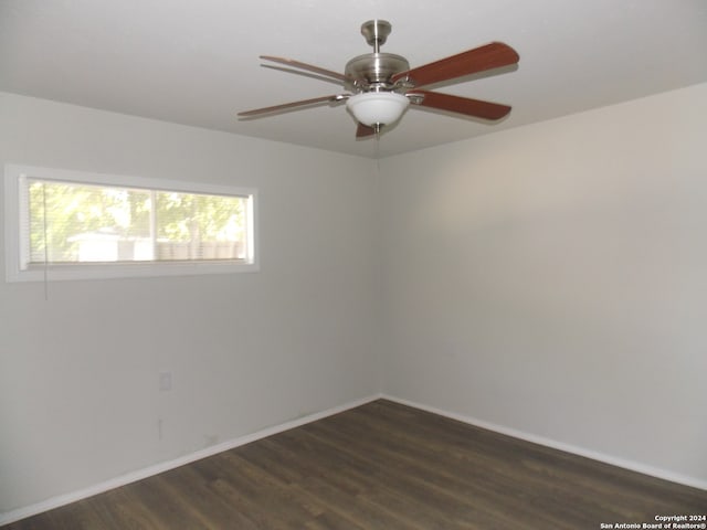 unfurnished room featuring dark wood-type flooring and ceiling fan