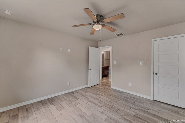 unfurnished room featuring light wood-type flooring and ceiling fan