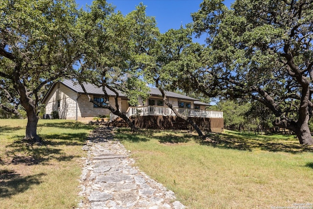 view of front facade featuring a front yard and a deck