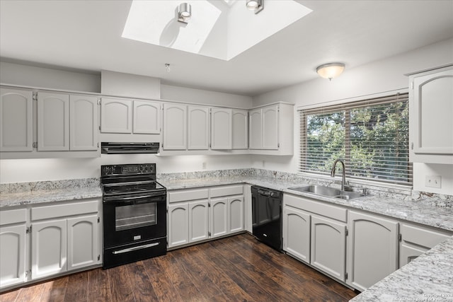 kitchen featuring a skylight, white cabinetry, sink, black appliances, and dark wood-type flooring