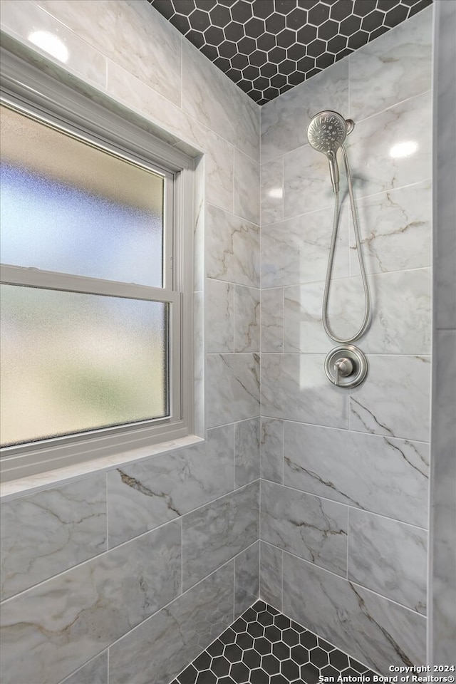 bathroom featuring a tile shower and plenty of natural light