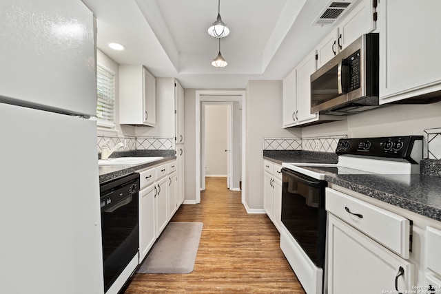 kitchen featuring white appliances, backsplash, white cabinetry, and light hardwood / wood-style flooring