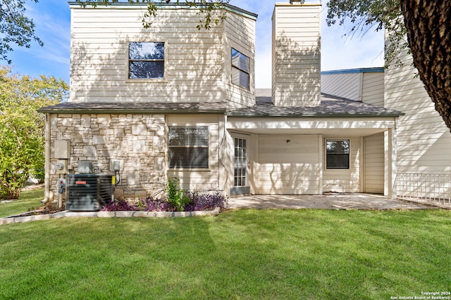 back of house featuring a yard and central AC unit