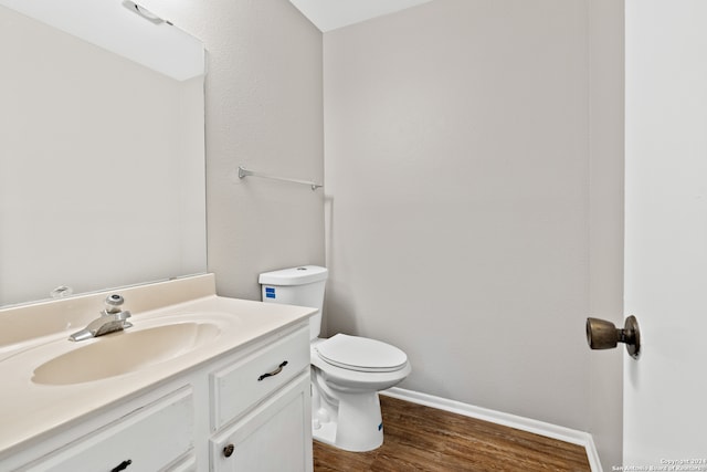 bathroom featuring vanity, toilet, and hardwood / wood-style flooring