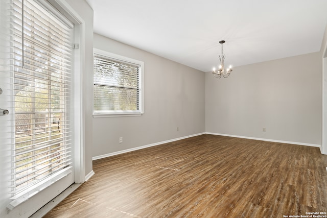 spare room with light hardwood / wood-style flooring and a notable chandelier