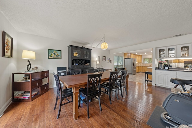 dining room featuring dark hardwood / wood-style floors and a textured ceiling