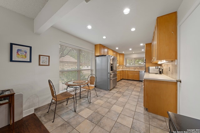 kitchen featuring light tile patterned floors, stainless steel appliances, and tasteful backsplash