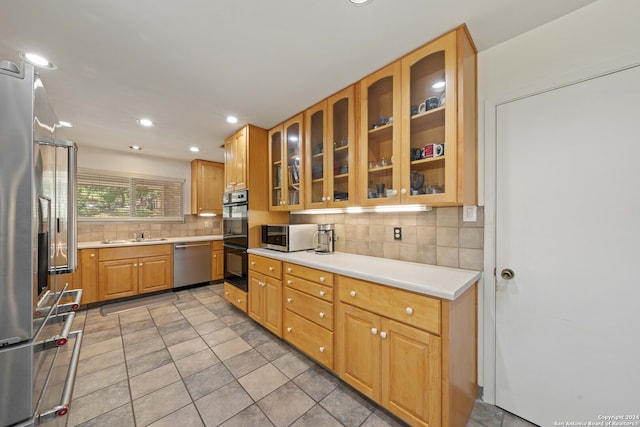 kitchen featuring stainless steel appliances, tasteful backsplash, and light tile patterned flooring