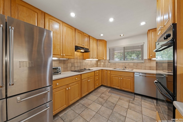 kitchen with stainless steel appliances, sink, light tile patterned floors, and decorative backsplash