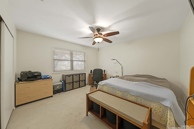 carpeted bedroom featuring ceiling fan and a closet