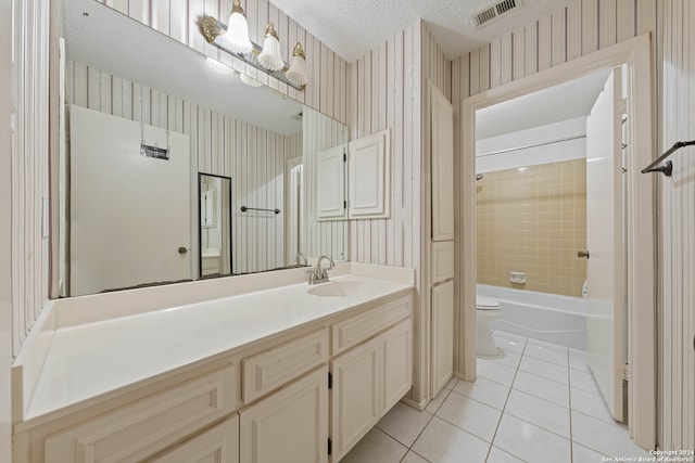 full bathroom featuring toilet, tile patterned flooring, vanity, a textured ceiling, and tiled shower / bath combo