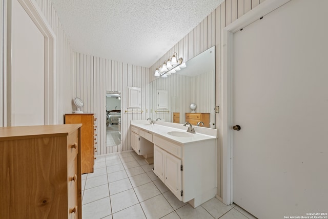 bathroom with tile patterned flooring, vanity, and a textured ceiling