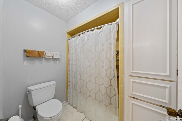 bathroom featuring toilet, walk in shower, and a textured ceiling