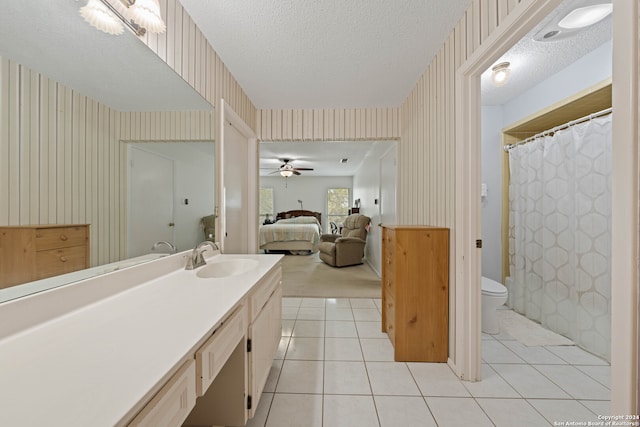 bathroom featuring a textured ceiling, vanity, toilet, and tile patterned flooring