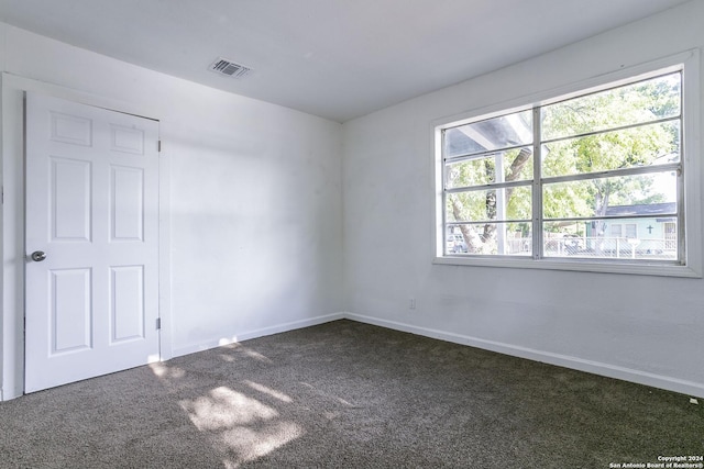 spare room with carpet, visible vents, and baseboards