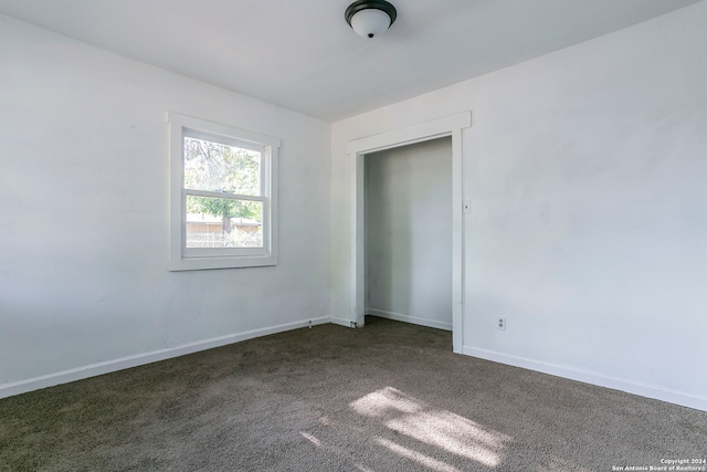 empty room featuring dark colored carpet