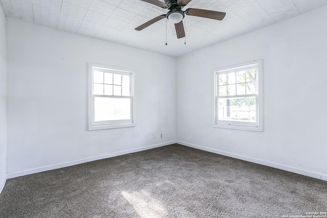 spare room with ceiling fan, carpet, and baseboards