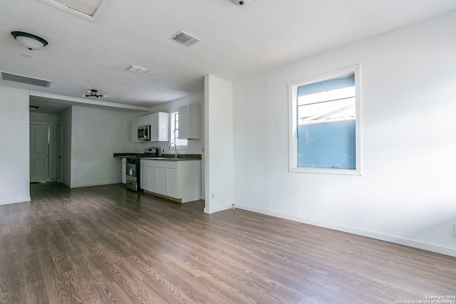 unfurnished living room featuring dark wood-type flooring and sink