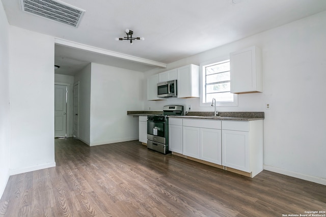 kitchen featuring dark wood-type flooring, sink, appliances with stainless steel finishes, and white cabinetry