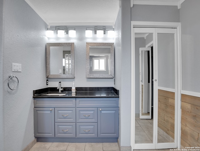 bathroom with ornamental molding, tile patterned flooring, and vanity