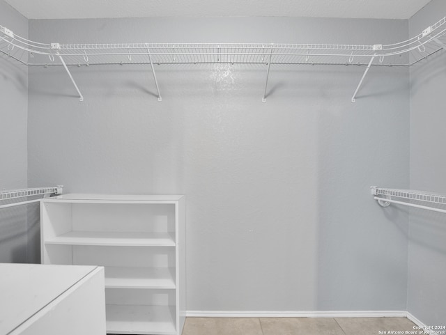 spacious closet with light tile patterned floors