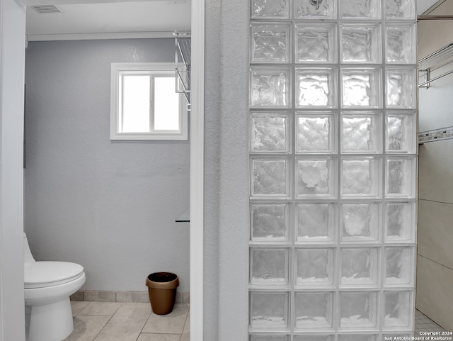 bathroom featuring tile patterned flooring, a shower, and toilet