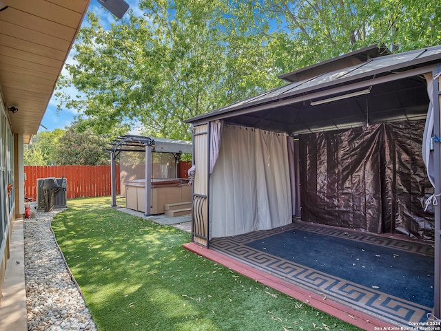 view of yard featuring a hot tub, a patio area, and a gazebo