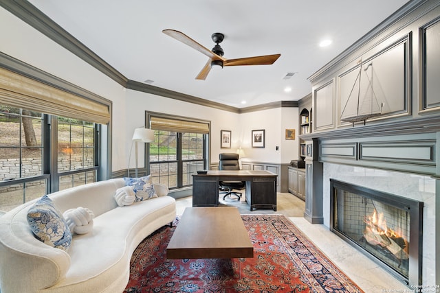 living room featuring crown molding, a fireplace, and ceiling fan