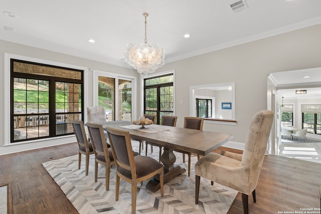 dining room featuring hardwood / wood-style flooring, crown molding, and a chandelier