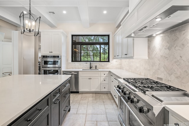 kitchen with pendant lighting, white cabinets, beam ceiling, custom exhaust hood, and stainless steel appliances