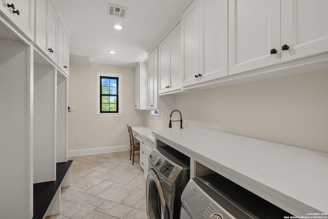 laundry room with cabinets, sink, and washing machine and dryer