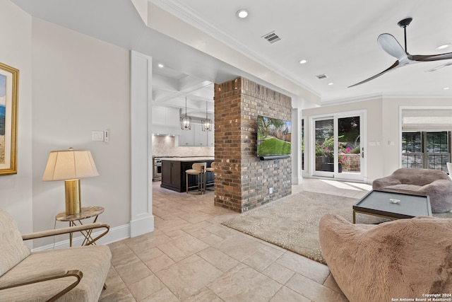 living room with ceiling fan with notable chandelier and ornamental molding