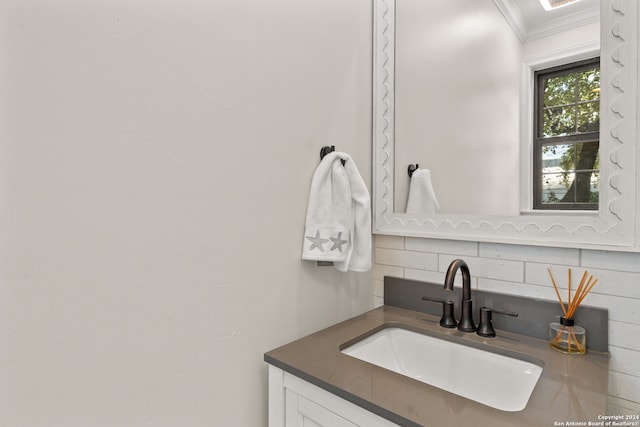 bathroom featuring vanity, ornamental molding, and tasteful backsplash