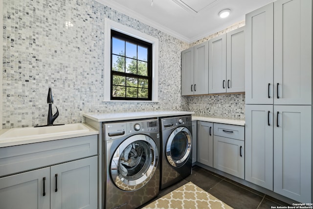 washroom with dark tile patterned flooring, sink, cabinets, crown molding, and washer and dryer