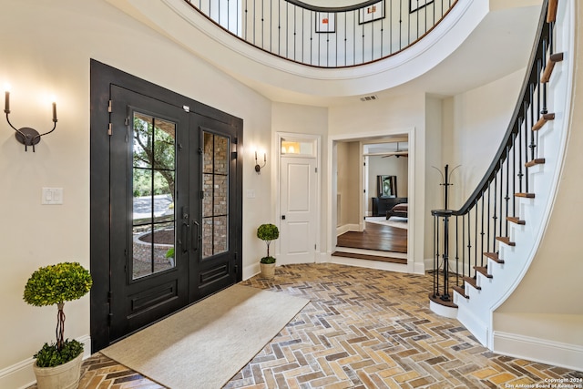 entryway featuring a high ceiling, ceiling fan, and french doors