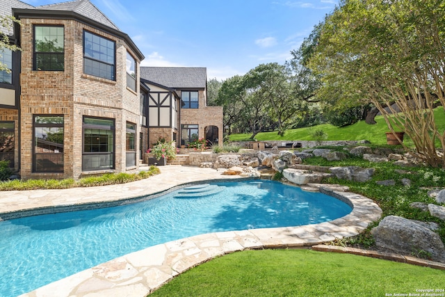 view of pool featuring a lawn