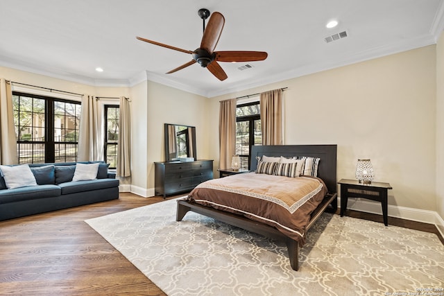 bedroom featuring ornamental molding, wood-type flooring, and ceiling fan