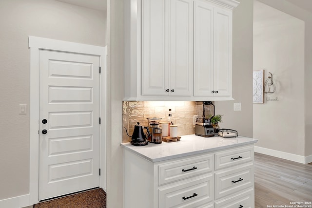 kitchen featuring white cabinets, tasteful backsplash, and light hardwood / wood-style flooring