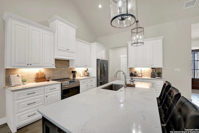 kitchen with a sink, visible vents, white cabinetry, appliances with stainless steel finishes, and decorative light fixtures