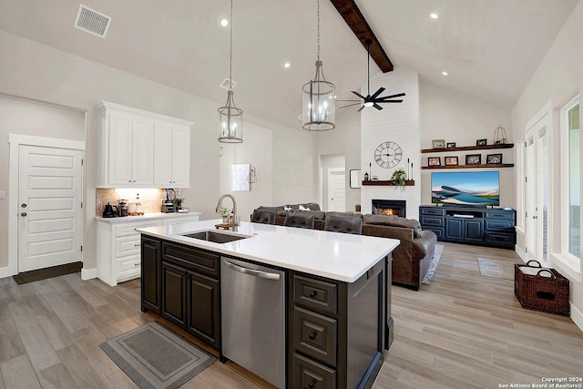 kitchen with light countertops, white cabinetry, a sink, an island with sink, and dishwasher