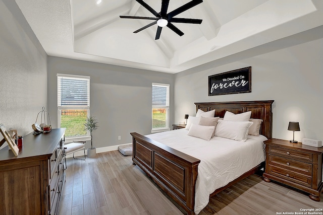 bedroom featuring light wood-type flooring, vaulted ceiling, and ceiling fan