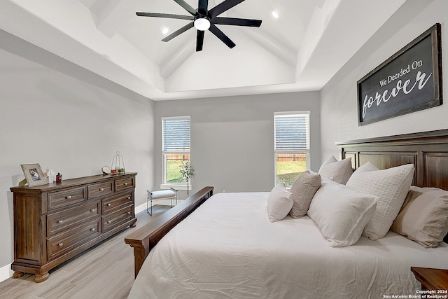 bedroom with multiple windows, lofted ceiling, ceiling fan, and light hardwood / wood-style floors