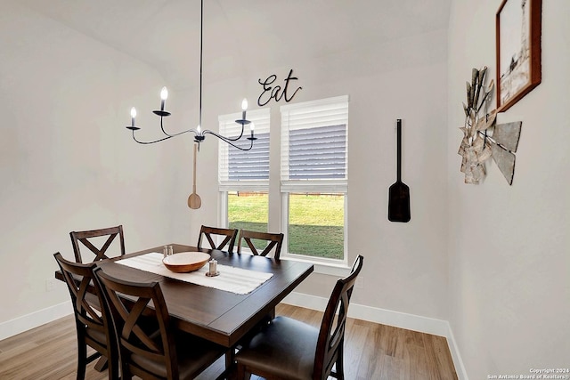 dining area featuring an inviting chandelier, baseboards, and wood finished floors