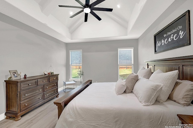 bedroom featuring lofted ceiling, light wood-style flooring, baseboards, and a ceiling fan