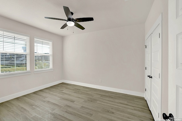 spare room with ceiling fan and light wood-type flooring